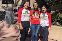 Three young women wearing red expressing their support for banning the sale of flavored tobacco products in Santa Ana, CA.